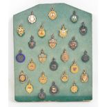 A collection of seventeen 9ct yellow gold and nine sterling silver 1920s football medals awarded to