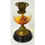 An Art Nouveau oil lamp with embossed brass column, circular base and cut clear glass reservoir,