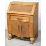 A mid 20th century oak bureau with interior pigeon holes and drawer above one drawer and two