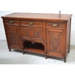 An early 20th century mahogany sideboard with carved urn and swag decoration to panelled doors,