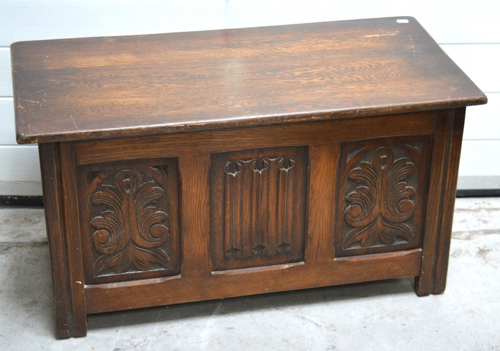 A 20th century oak blanket chest with foliate carved front panels, width 91cm.