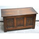 A 20th century oak blanket chest with foliate carved front panels, width 91cm.