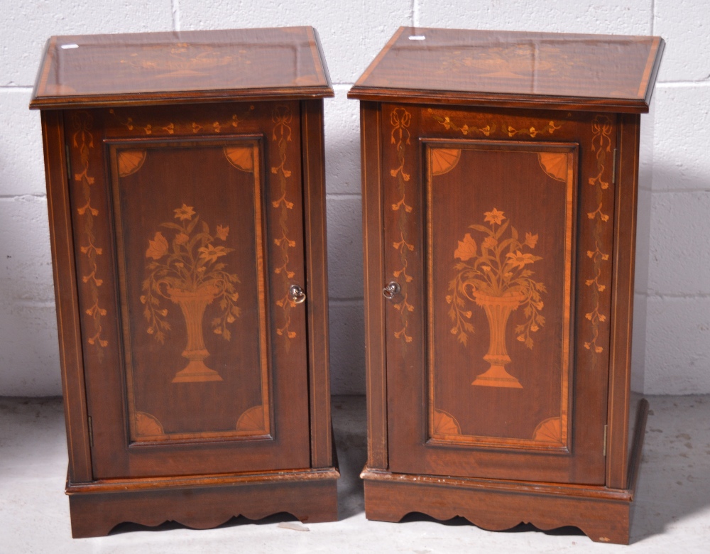 A pair of 20th century mahogany bedside cabinets with Art Nouveau floral ribbon and swag inlay on a