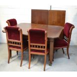 An Edwardian mahogany and inlaid extending dining table on castors,