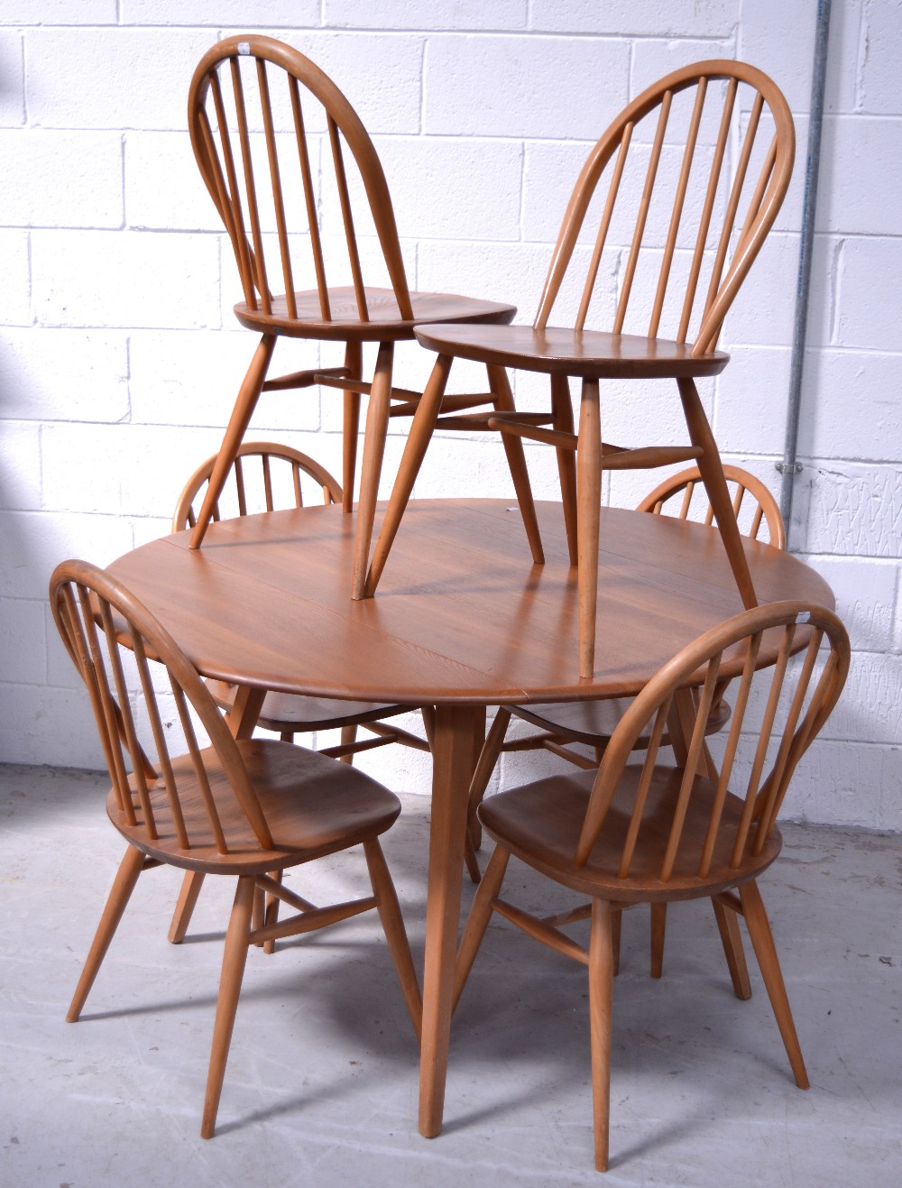 A retro Ercol extending dining table on tapering legs,