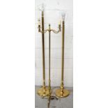 Three brass standard lamps, the largest presented with reeded column support and rounded base,