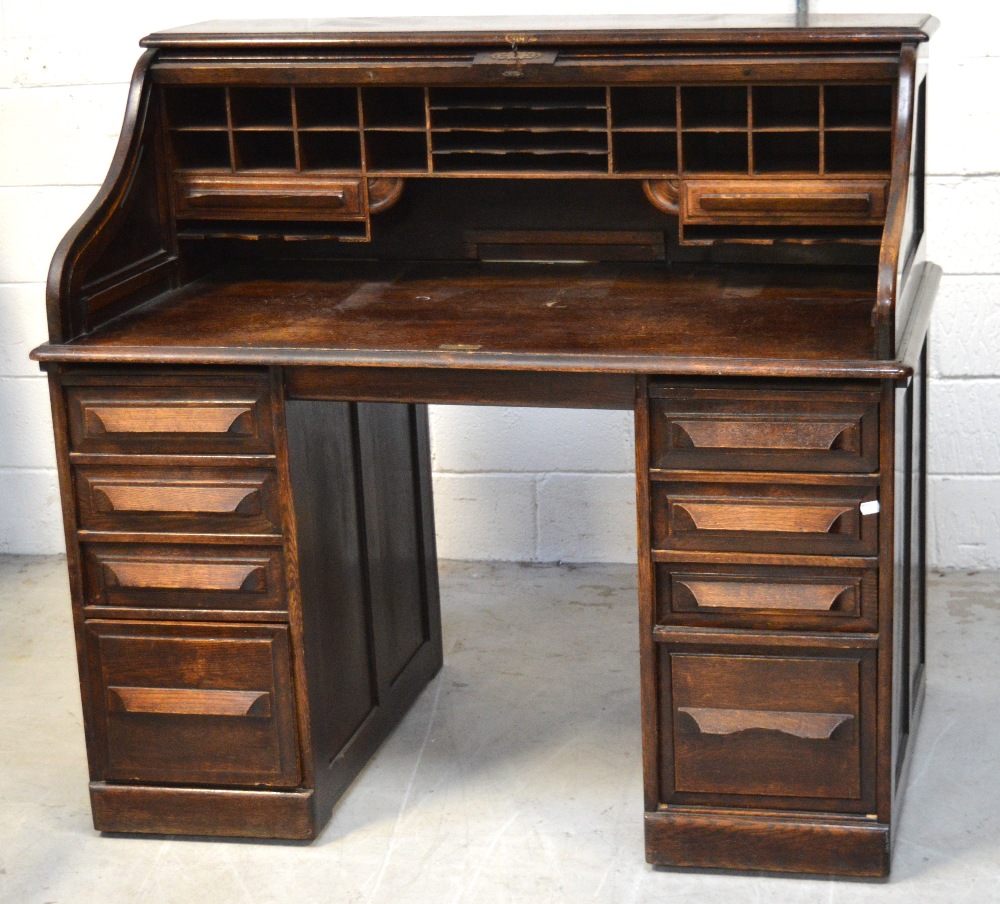 An oak eight drawer roll top bureau, width 125cm.