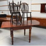 An mahogany extending dining table on turned legs,