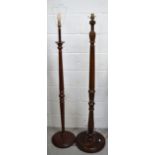 Two wooden standard lamps, both on rounded bases, height of both approx 140cm.