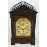 A late 19th century mahogany bracket clock with pediment top decorated with a cherub face and wings,