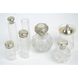 A George V hallmarked silver topped clear cut glass globular scent bottle embossed with floral and