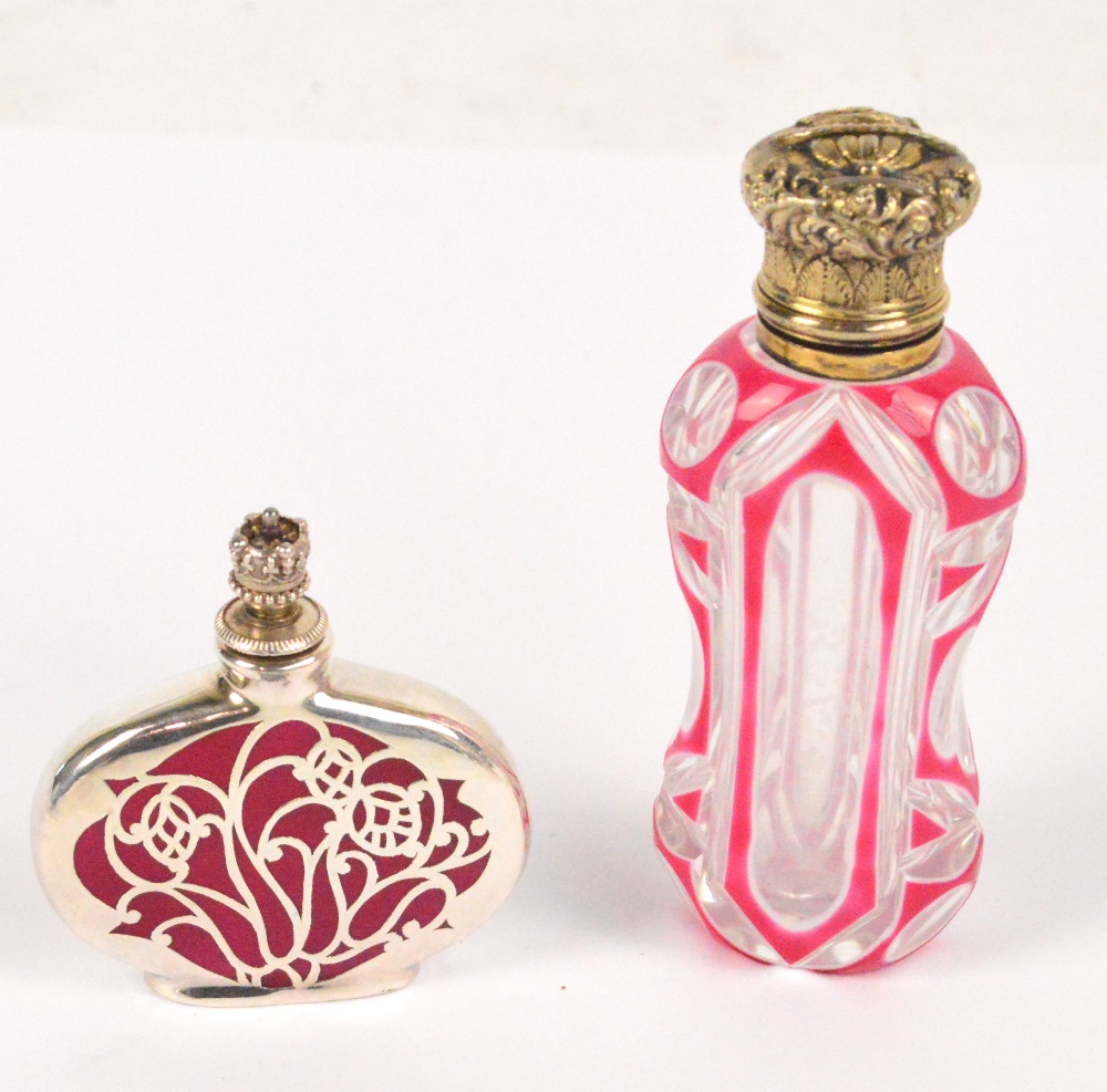 A white gilt metal topped scent bottle with clear glass pink enamel overlaid body in the manner of