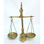 A brass beam scale by Libra & Co with shaped base with inset brass weights, height 55cm.
