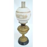 A Victorian oil lamp with brass reservoir on spreading circular ornamental foot with turned base,