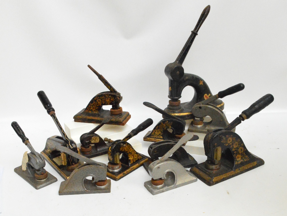A collection of vintage cast iron paper seal embossing machines, of various sizes,