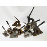A collection of vintage cast iron paper seal embossing machines, of various sizes,