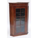 A Georgian mahogany flat fronted corner cupboard with fluted sides flanking glazed door enclosing