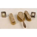 A George V hallmarked silver backed three piece dressing table set comprising a hand brush and pair