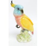 A Beswick 1180 model of a small cockatoo in turquoise, pink and yellow colourway, height 21cm.