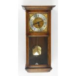 A modern oak cased eight day chiming wall clock, the silvered chapter ring set with Roman numerals,