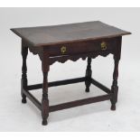 An 18th century oak side table with plank top above single frieze drawer and shaped apron,