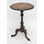 A late Victorian walnut and inlaid shaped top occasional table raised on three scrolling supports,