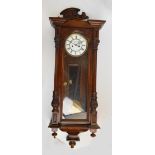 A late 19th century walnut Vienna style twin weight wall clock with white enamel dial inscribed
