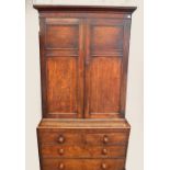 A late George III oak and mahogany crossbanded two door bookcase with panelled doors and moulded