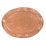 A very large Arts and Crafts copper hammer decorated oval tray with raised crimped rim, 74 x 54.5cm.