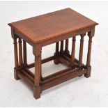 An oak nest of three tables with ring turned stretchered supports, 56 x 35cm.