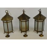 A set of three hexagonal pendant lanterns with metal tops and shaped frosted glass panels with