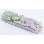 A Chinese jade belt hook carved with a stylised dragon with hints of pale green and pale purple to