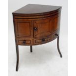 An early 19th century mahogany and ebony strung corner wash stand with rising cover enclosing cut