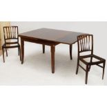 A mahogany dining suite comprising a rounded rectangular drawleaf dining table,