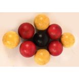 A group of nine late 19th century snooker balls including four red tinted examples and one black