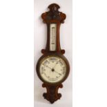 A 1920s carved oak banjo aneroid barometer/thermometer, height 76cm.