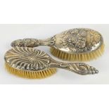 A George V hallmarked silver backed hand brush embossed with cherubic motifs amongst clouds,