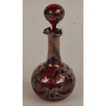 A late 19th century ruby glass silver overlaid scent bottle of bulbous form with scroll and floral