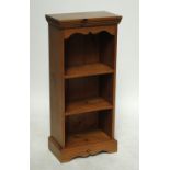 A small pine bookcase with stepped frieze pediment above three shelves on plinth base, height 101cm,