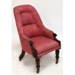 An early Victorian mahogany framed upholstered armchair raised on ring turned tapering front legs