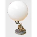 An Art Deco style table lamp with large globular white opaque glass shade on a geometrically