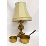 A decorative brass cherubic set table lamp and a pair of graduated brass pans (3).