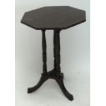 An octagonal occasional table raised on three turned supports with tripartite base on outswept feet,