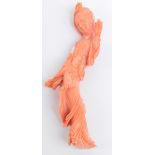 A Chinese carved coral figure of a young woman holding her left hand aloft, length 11.