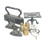 A quantity of metalware items comprising three flat irons including a large example, a teapot stand,