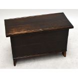 An 18th century oak plank coffer of rectangular tapering form, with hinged lid and adzed edges,