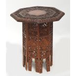 A 1920s Anglo Indian carved wood octagonal table decorated with various animals amongst foliate