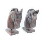 A pair of large modern carved wooden decorative horse's heads on rectangular bases, height 55cm.