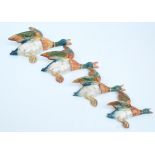 A set of four graduated Beswick flying ducks wall plaques, largest length 26cm, smallest 14.5cm (4).