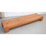 A pitch pine long low rectangular table on block supports, 214 x 58cm.